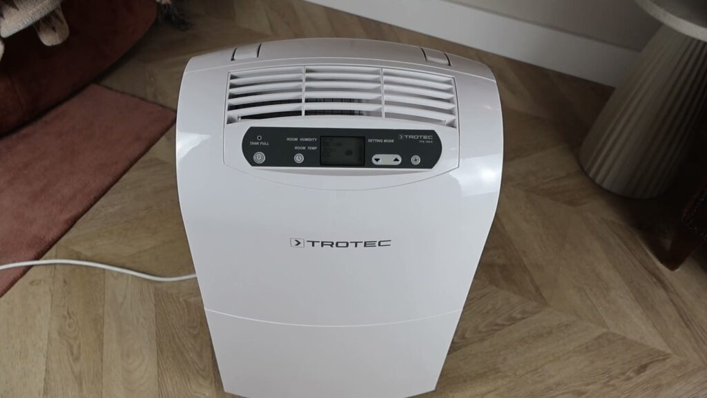 Luftentfeuchter Trotec TTK 100 E von oben gesehen auf einem Fischgrätparkett im Wohnzimmer