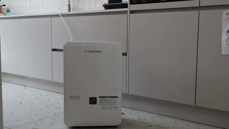 Luftentfeuchter Trotec TTK 127 E mit Ablassschlauch vor den Küchenschränken
